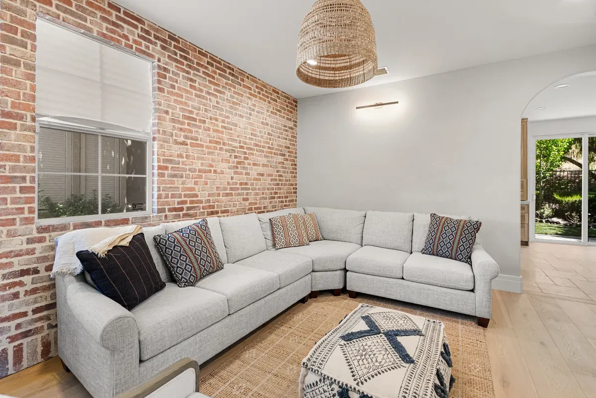 Living room with exposed brick wall, arched doorway and sectional sofa, Dublin full home remodel