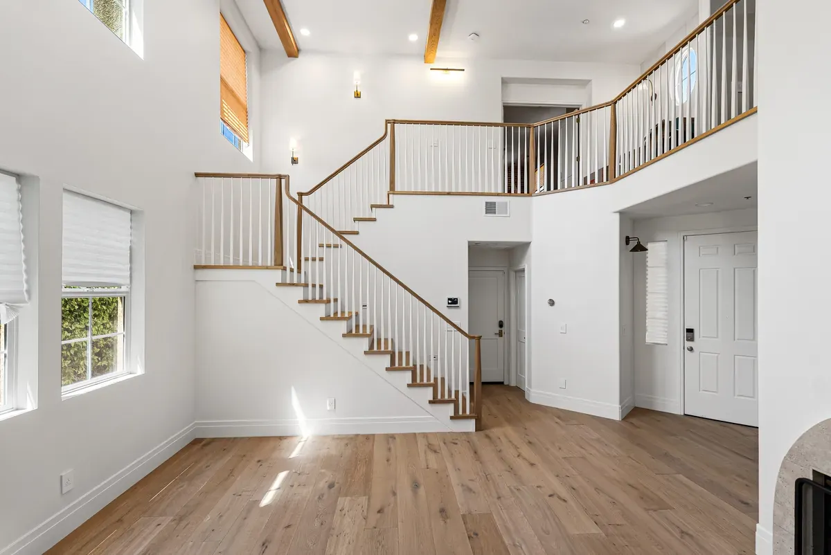 Double-height entry hall with wood staircase and white oak floors