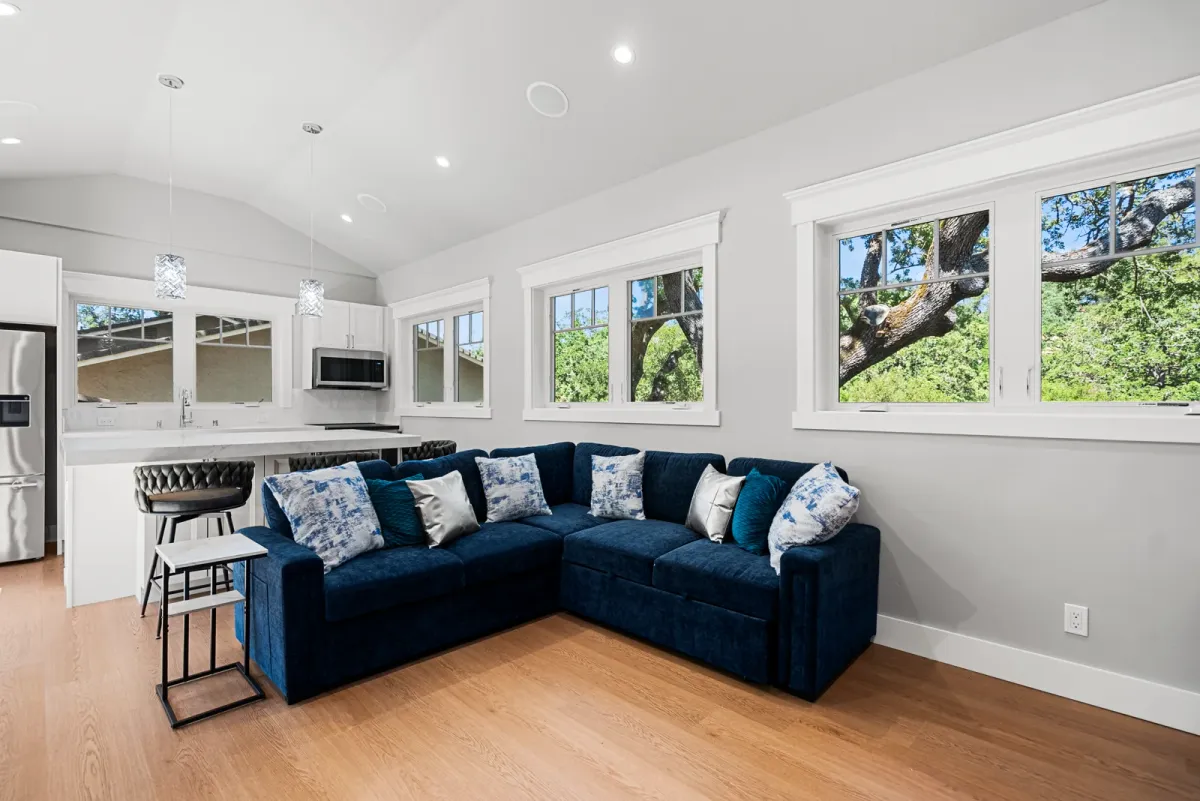 Vaulted living area with clerestory windows and a navy sectional, kitchen beyond, Monte Sereno JADU