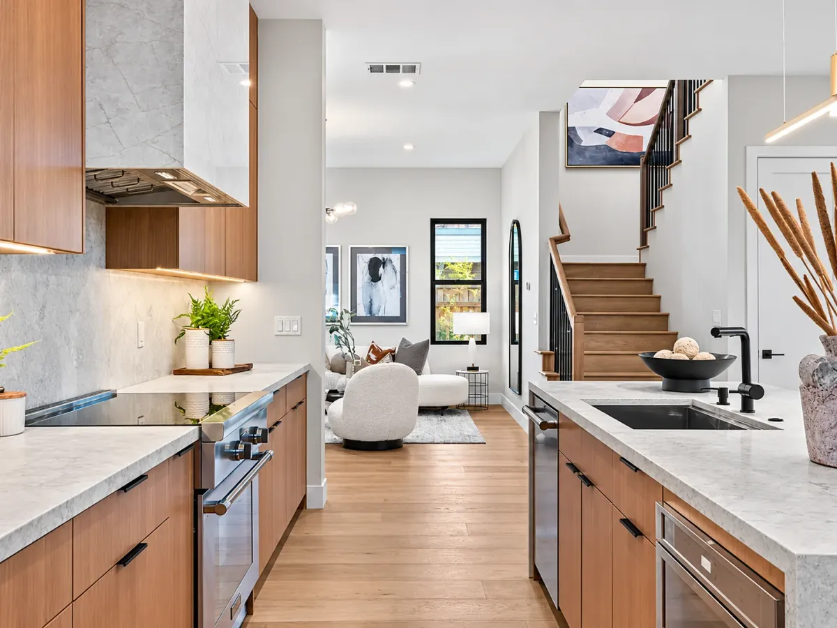Kitchen cooktop and marble slab backsplash, open to the living room and staircase