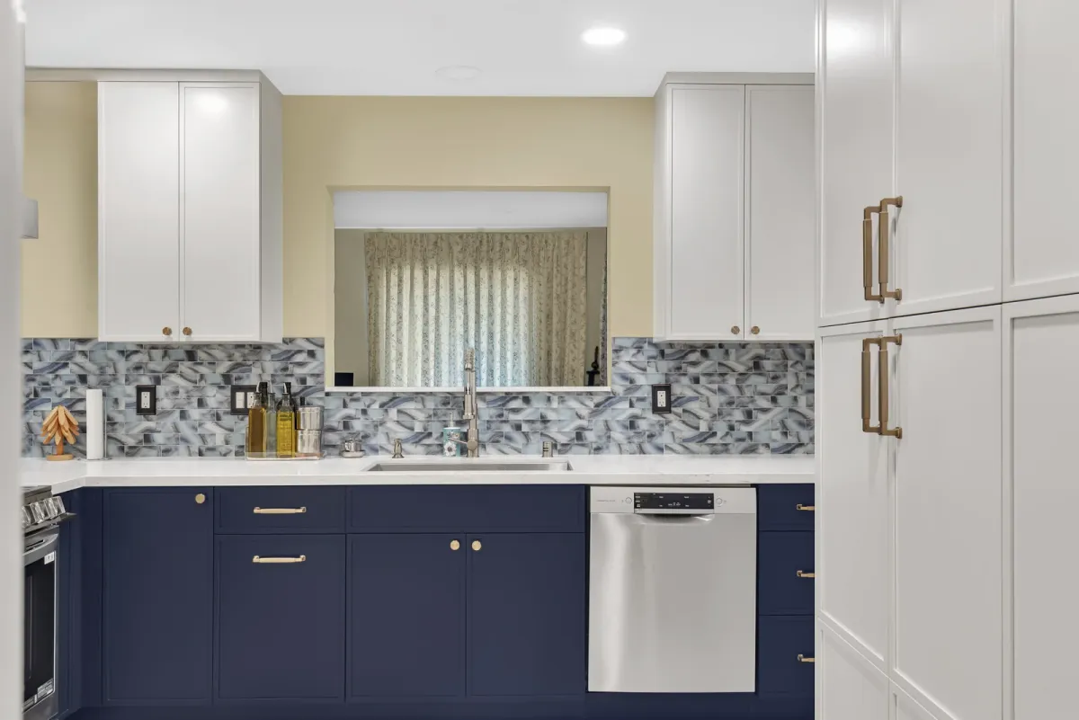 Navy cabinet run with a slide-in range and microwave drawer under a stainless island hood