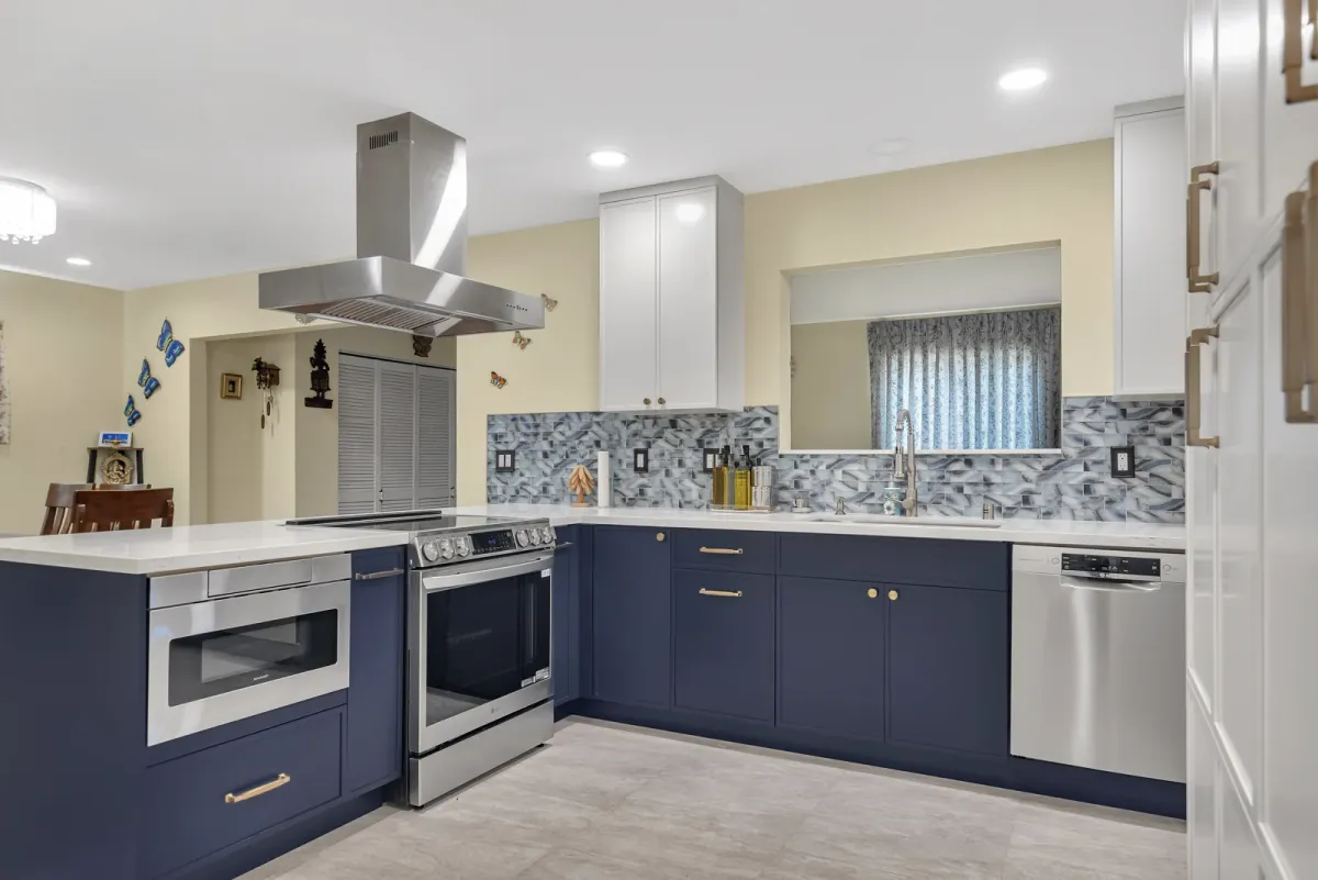 Quartz counter with a gooseneck faucet beside the range and island hood