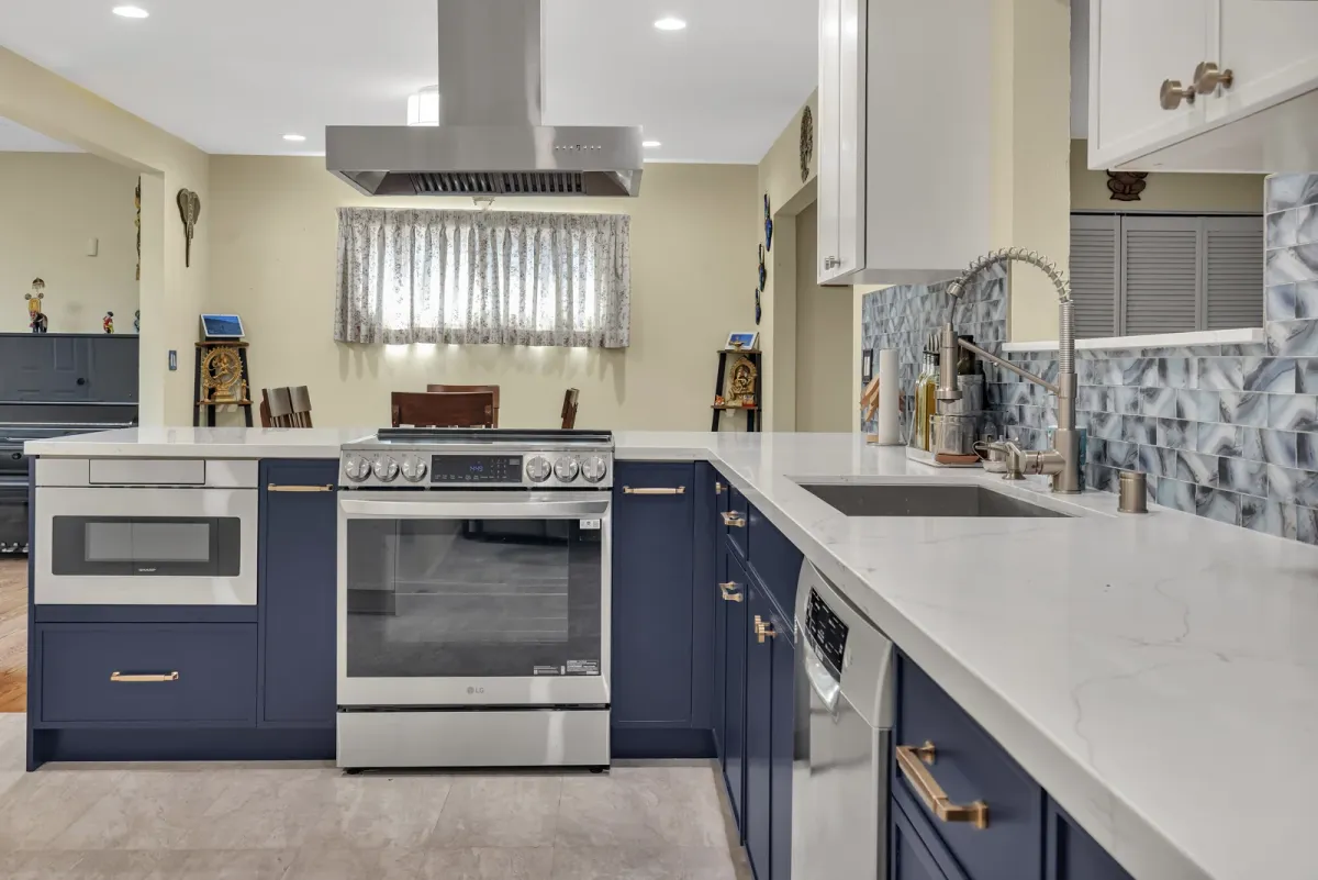 Range wall and sink counter against the blue-grey mosaic tile backsplash