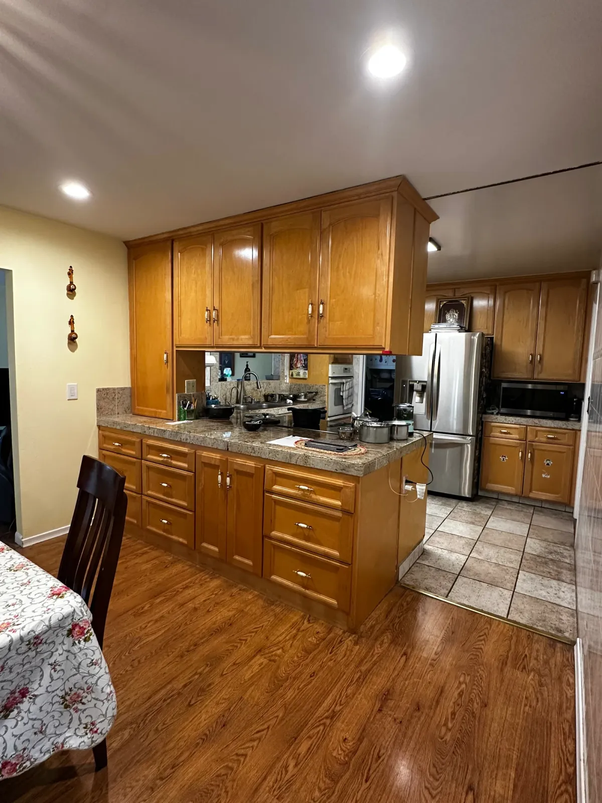 Before the remodel, dated oak cabinets with granite counters and a hardwood floor