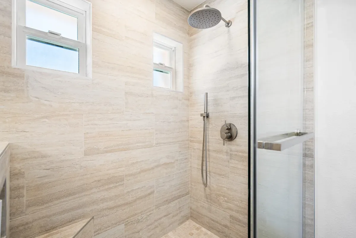 Walk-in shower with rain head and stone-look tile